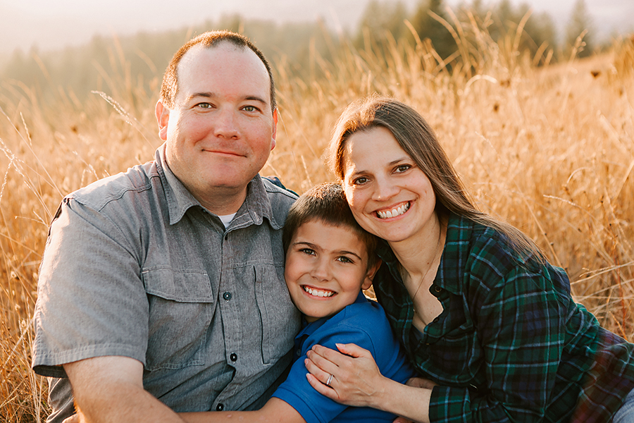 mother, father, and young boy sitting in a field at Fitton Green Corvallis