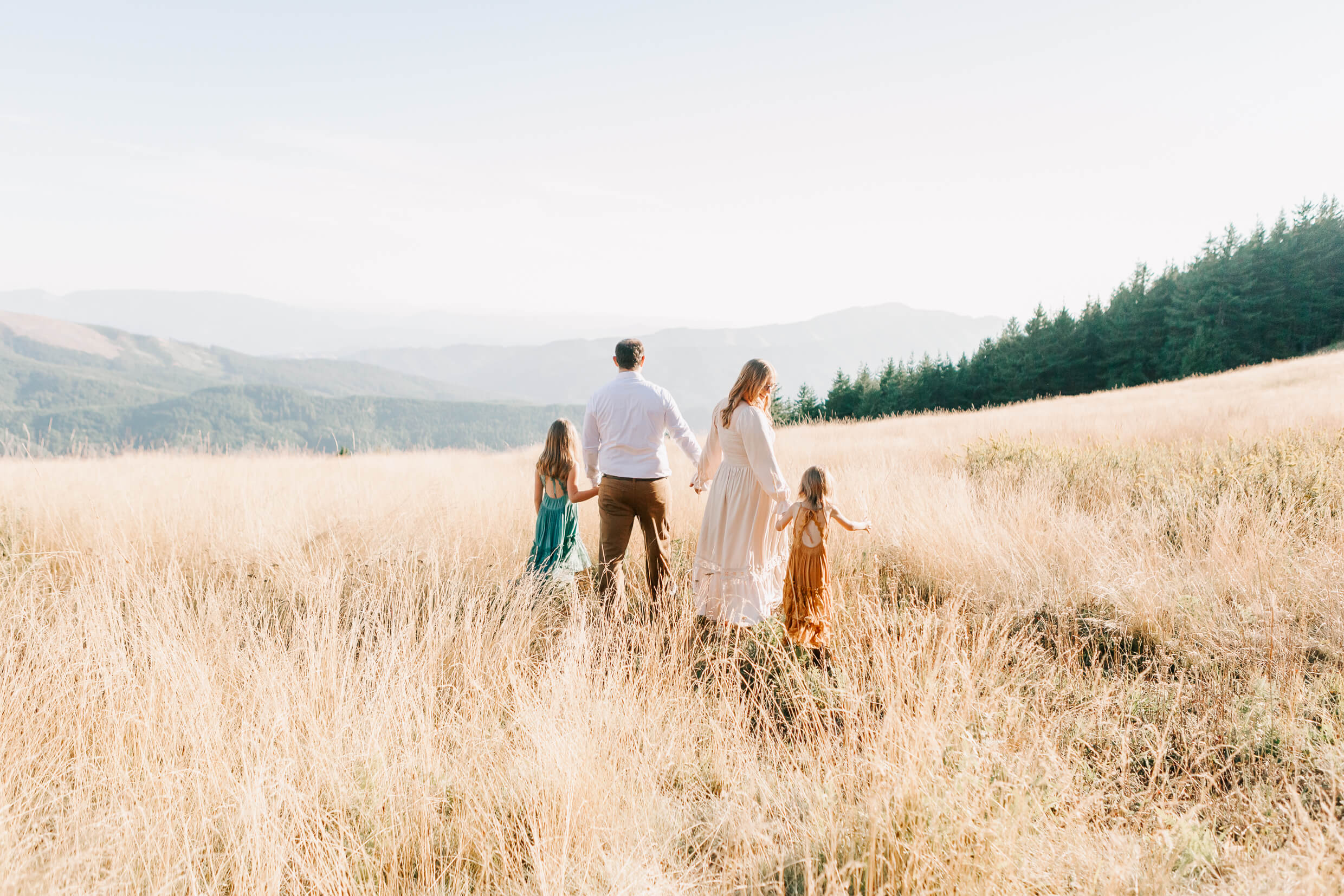 A family with mother, father, and two daughters walking at Mary's Peak, Oregon