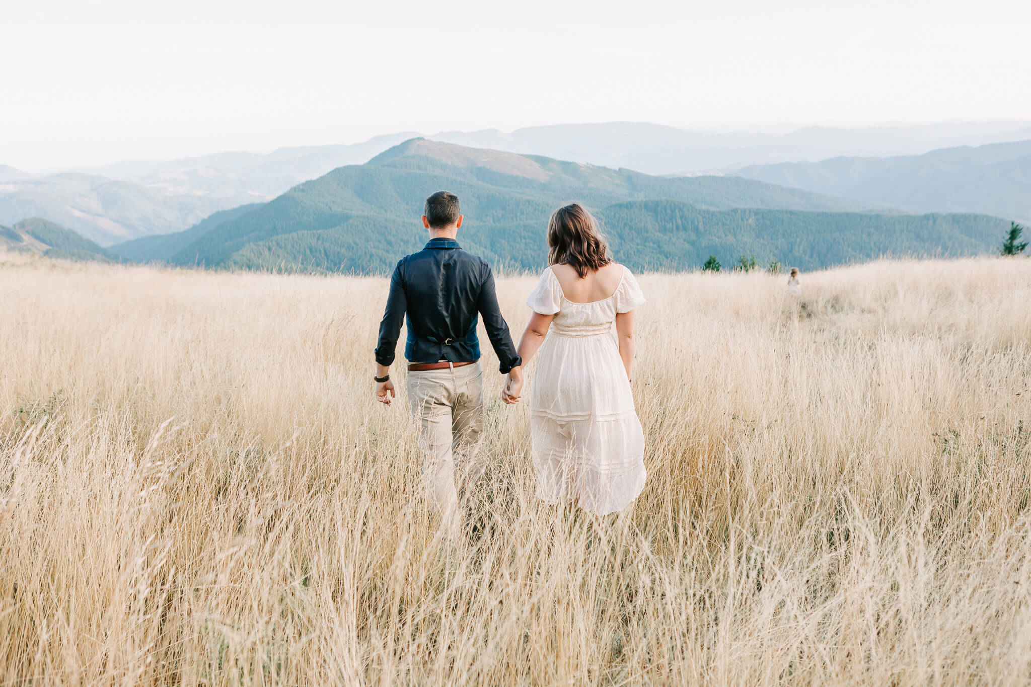 A man and woman hold hands walking at Mary's Peak Oregon