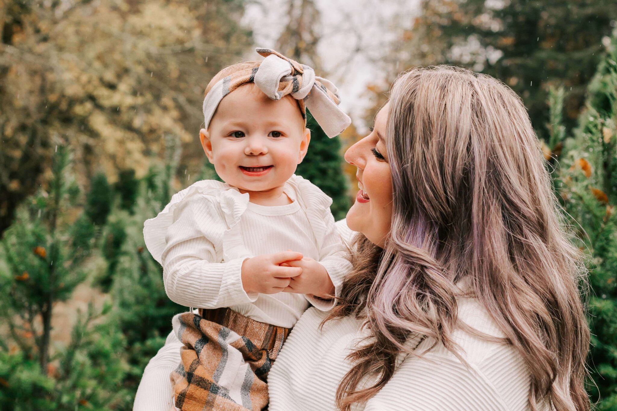 A mother holds her baby at Vitae Springs Christmas Tree Farm in Salem, OR