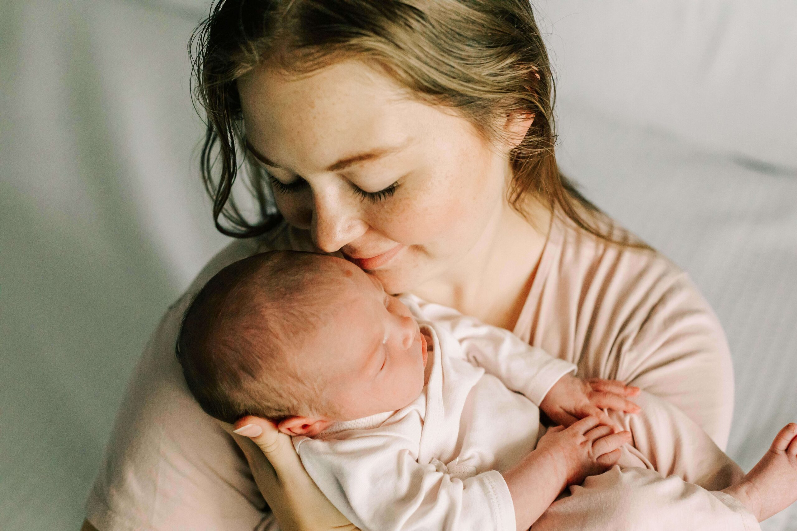 A mom cuddles her newborn baby in a newborn photo session with Jen White Photography in Albany Oregon