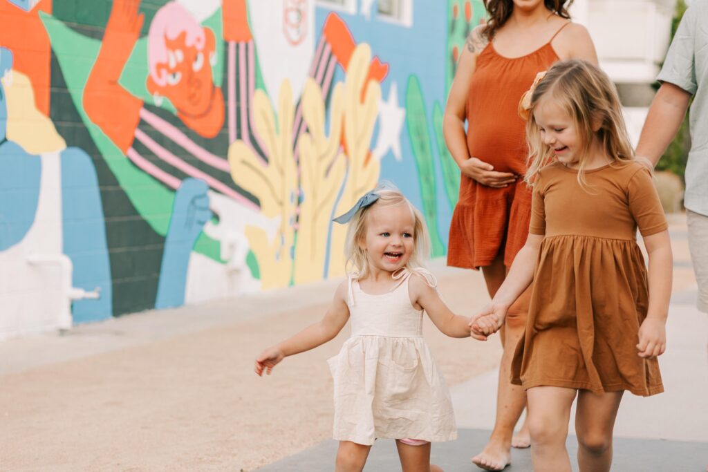 2 girls run holding hands