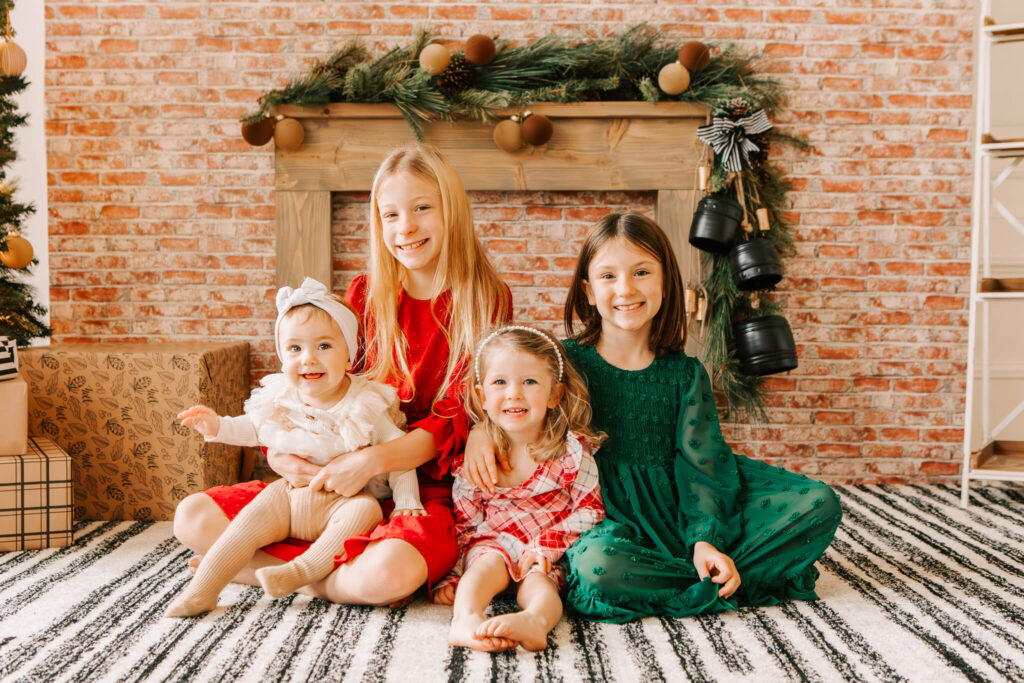 Siblings smiling during studio Christmas mini session in cozy Salem OR holiday setup