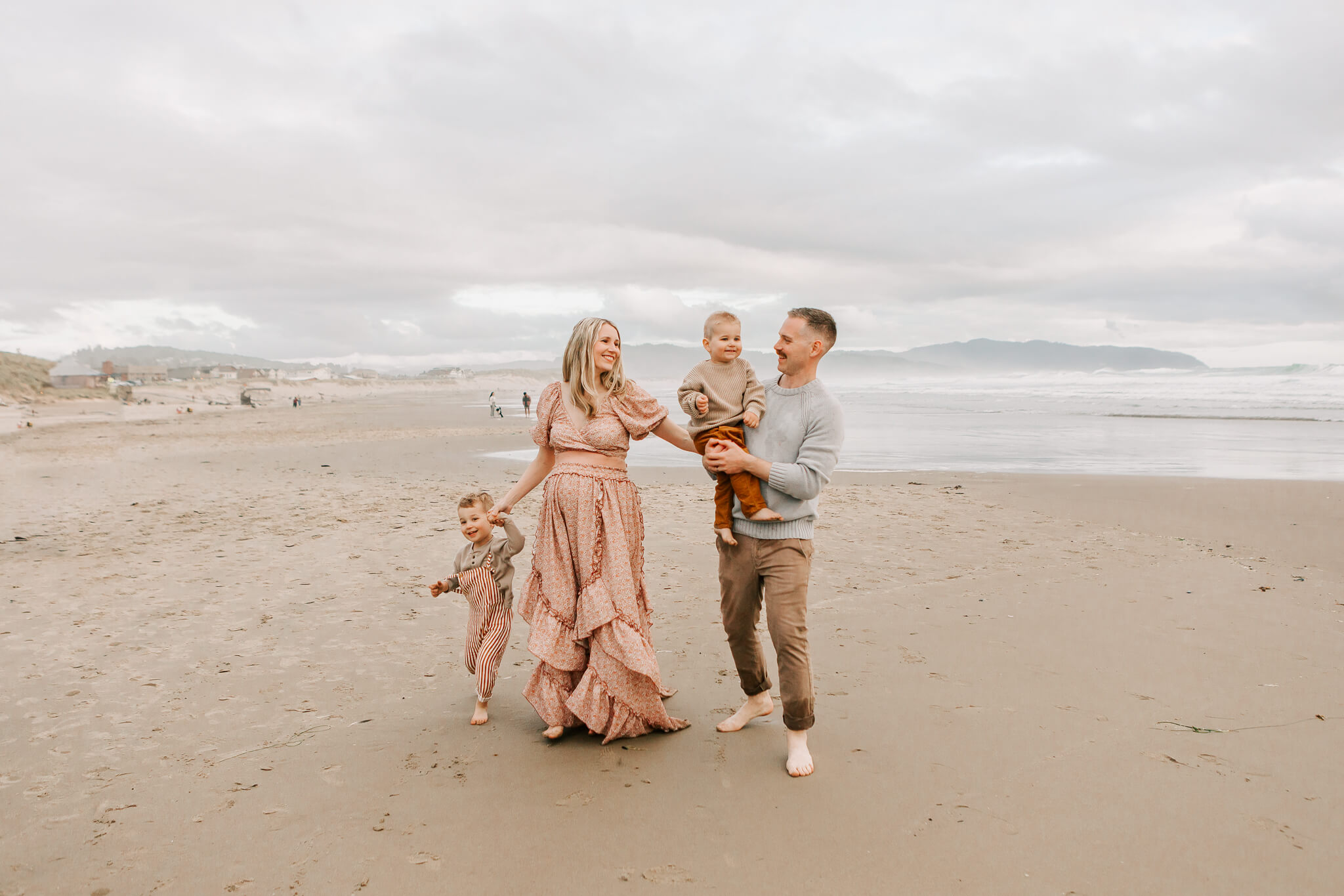 Family laughing together during Oregon spring break family photos on a windy beach