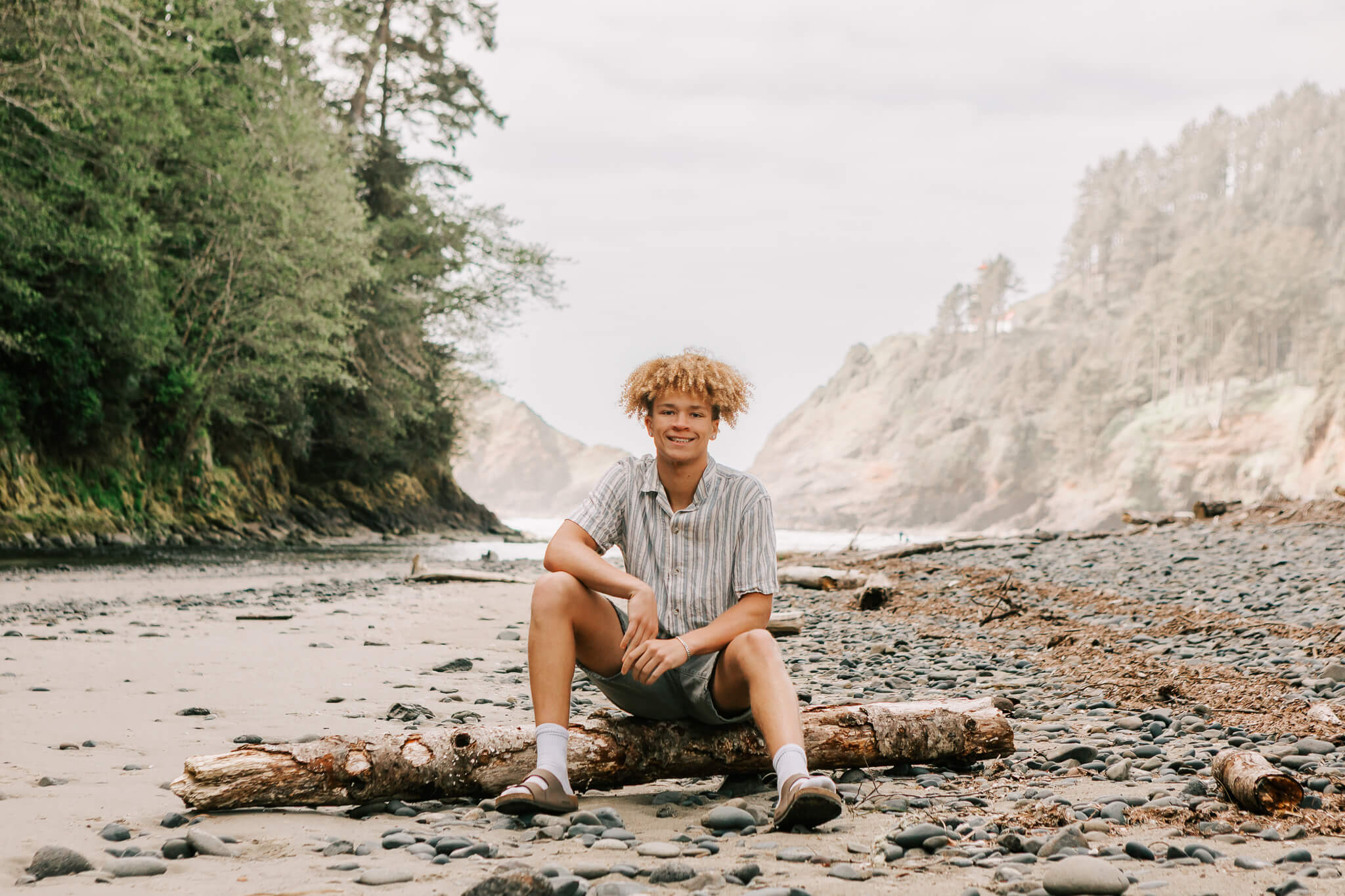 High school senior poses at Heceta Head Beach for senior portraits with Jen White Photography