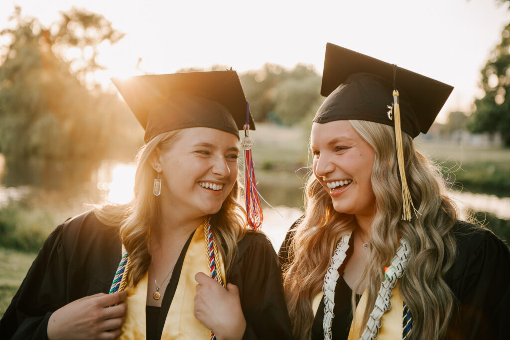High school senior girls laughing during cap and gown photography session