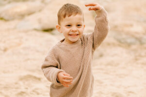 little boy plays on the beach
