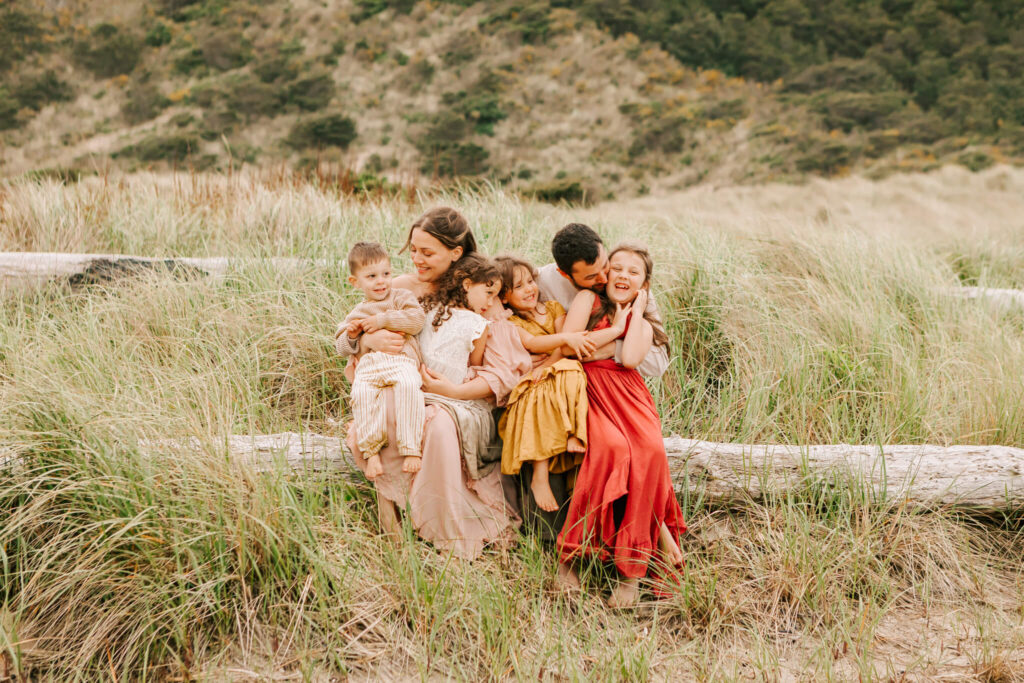 Family sits together on the beach during family photos with Jen White Photography of Albany OR
